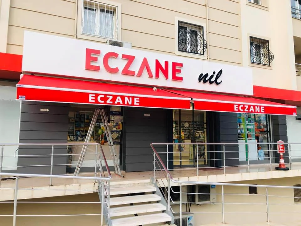 Eczane cephesinde kırmızı mafsallı tente uygulaması